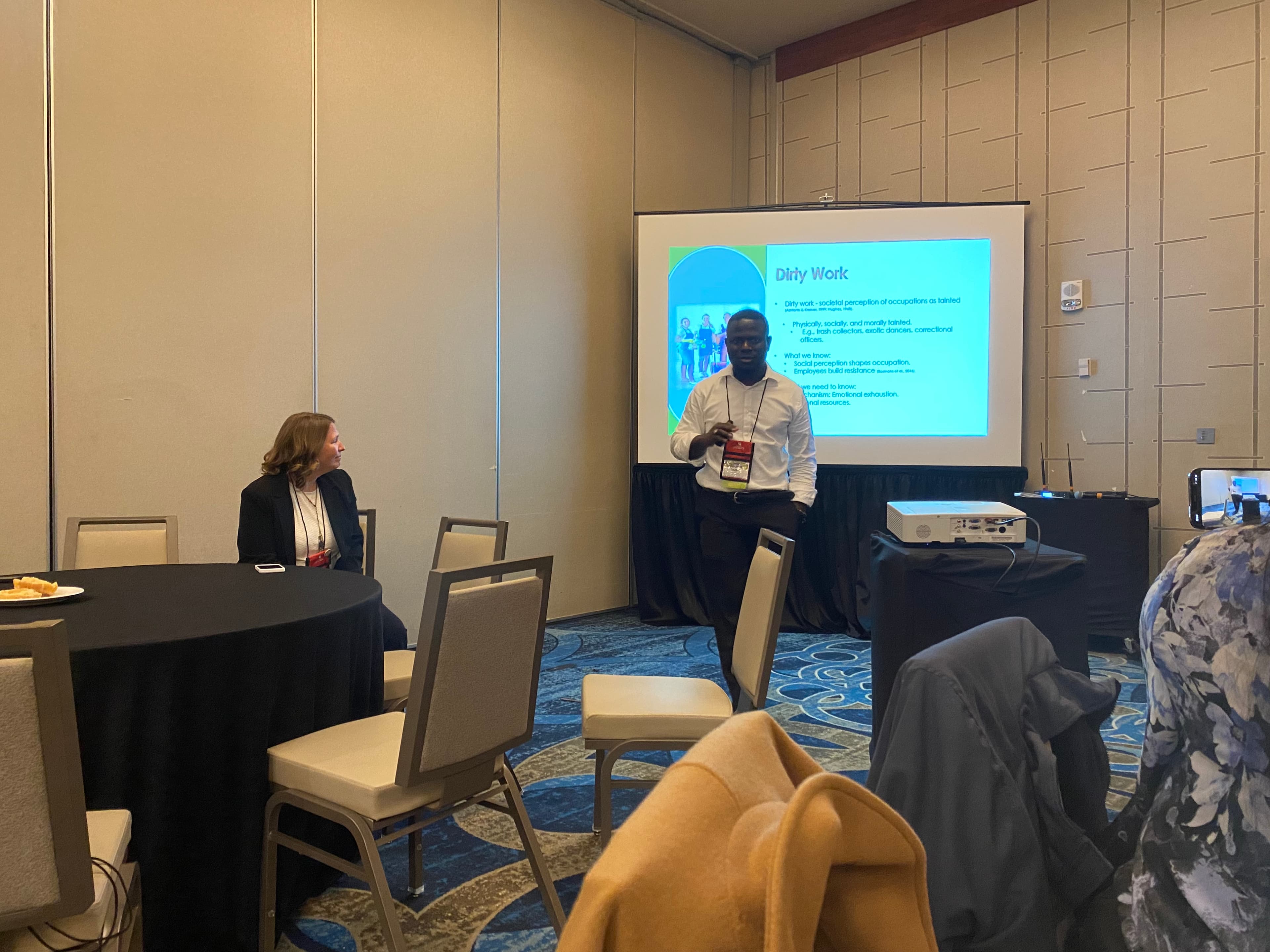 Sodiq Babatunde presenting research on dirty work and emotional exhaustion to a conference audience